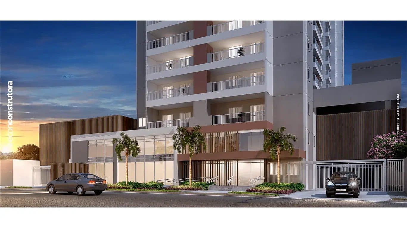 Fachada do edifício residencial à noite com portaria iluminada e carros estacionados.