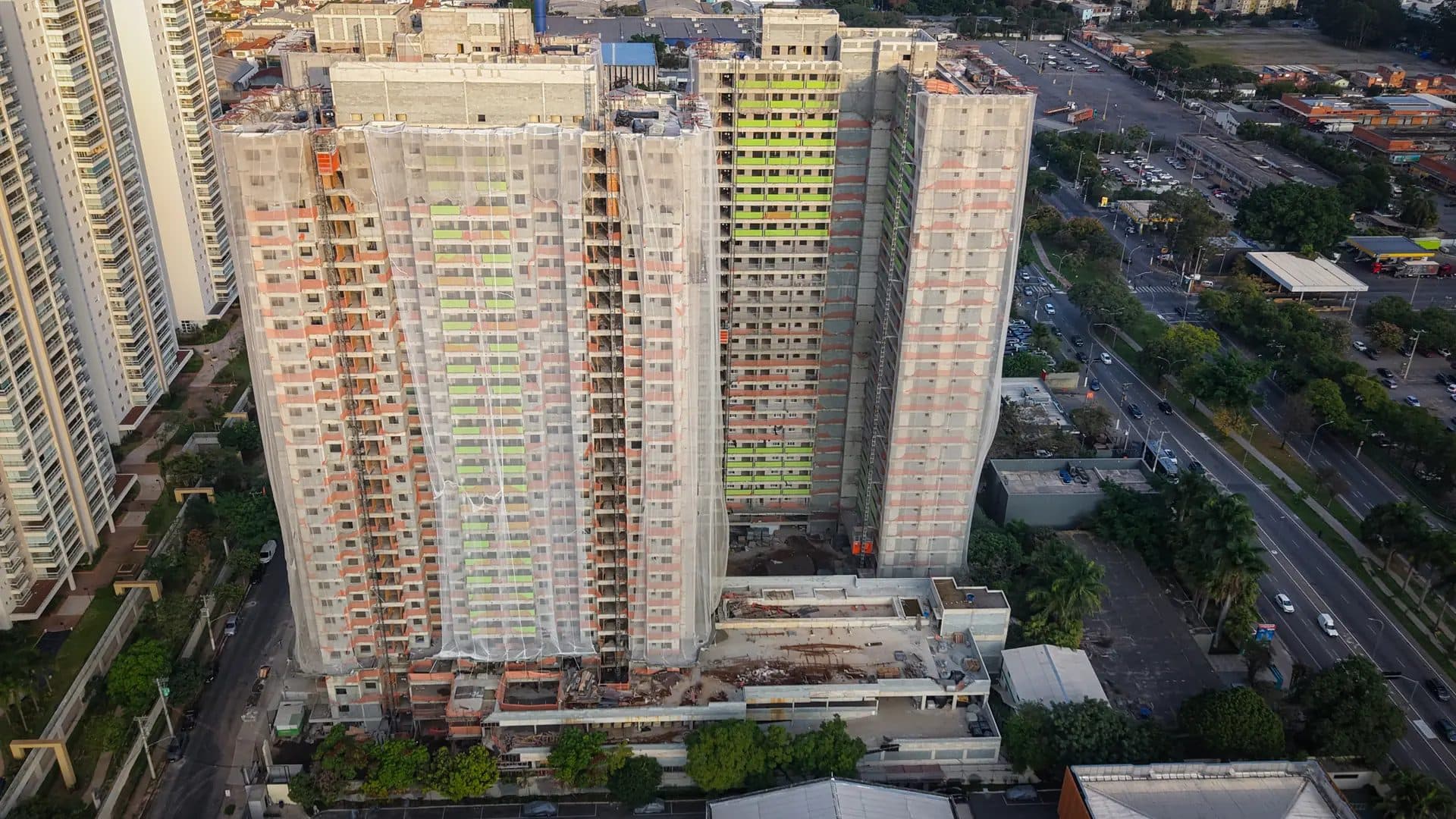 Vista superior detalhada dos edifícios em construção com redes de proteção.