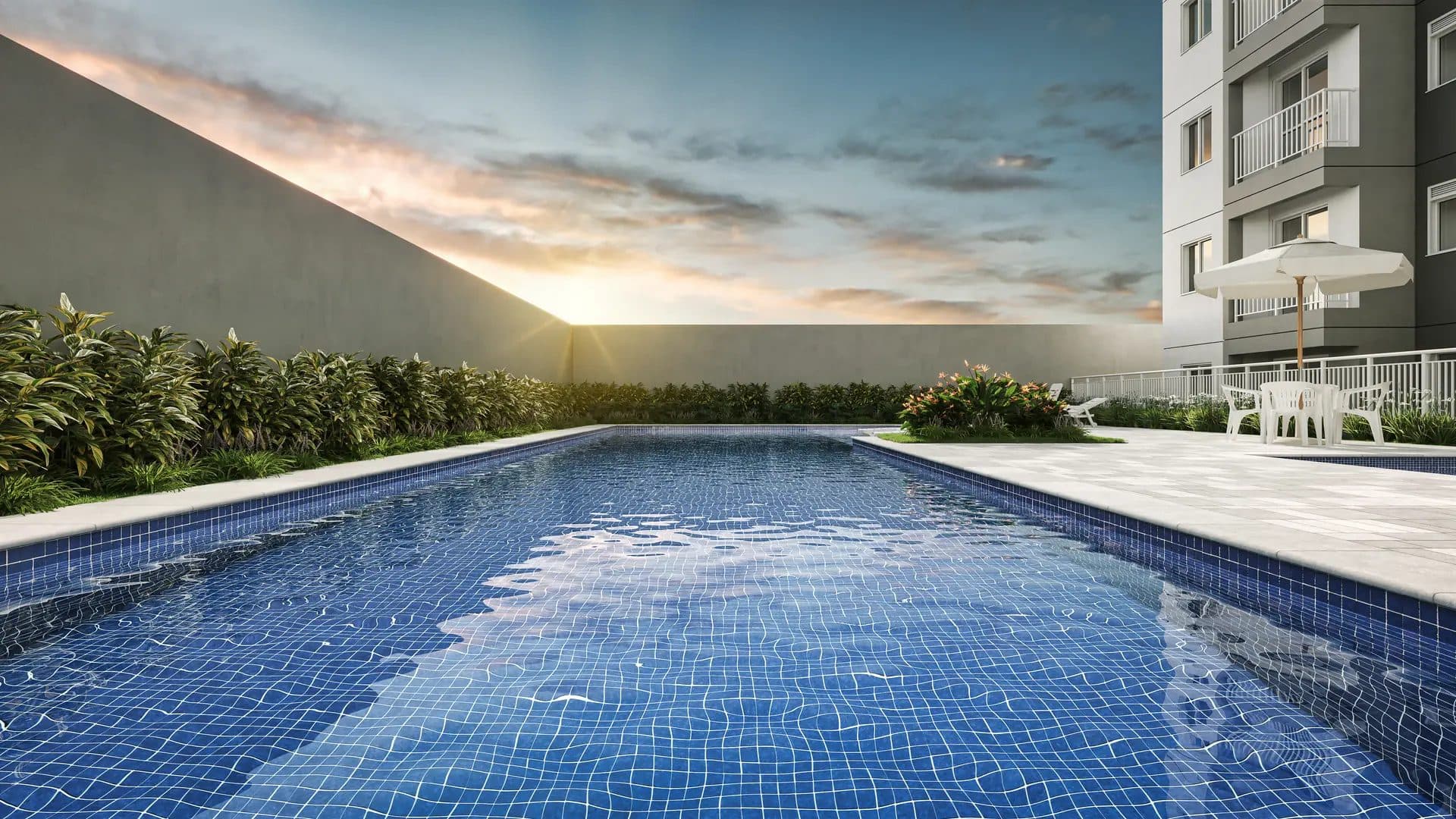 Piscina ao ar livre com azulejos azuis, espreguiçadeiras e paisagismo ao fundo.