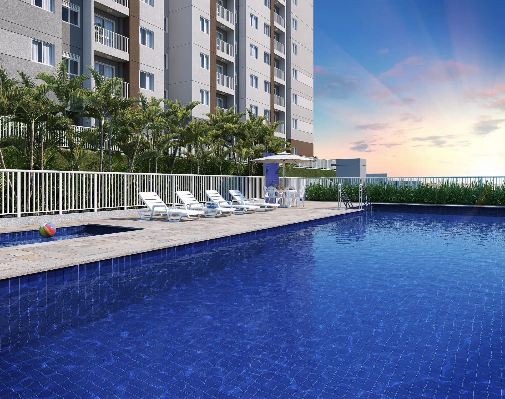 Piscina com deck de pedra, espreguiçadeiras, guarda-sol e paisagismo ao fundo.