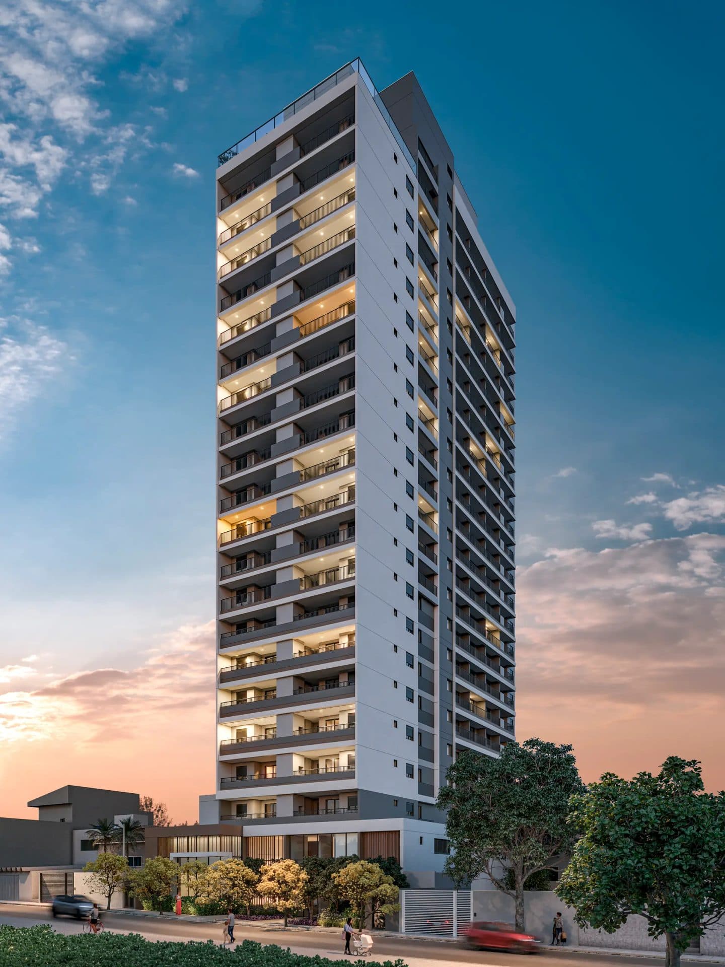 Fachada do edifício residencial moderno com varandas e iluminação acesa ao entardecer.