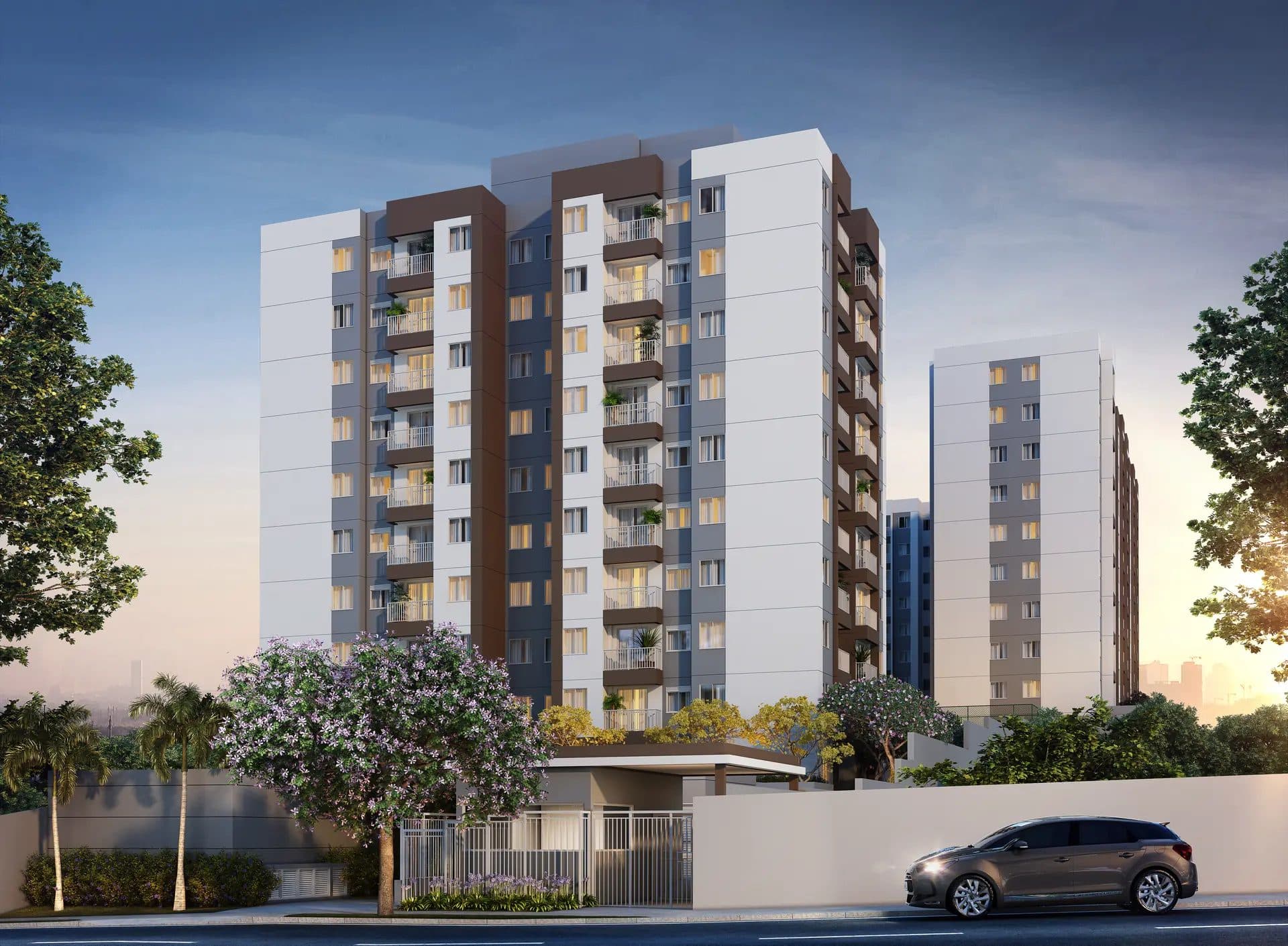 Fachada do edifício residencial com pintura em tons de branco, cinza e marrom e paisagismo.